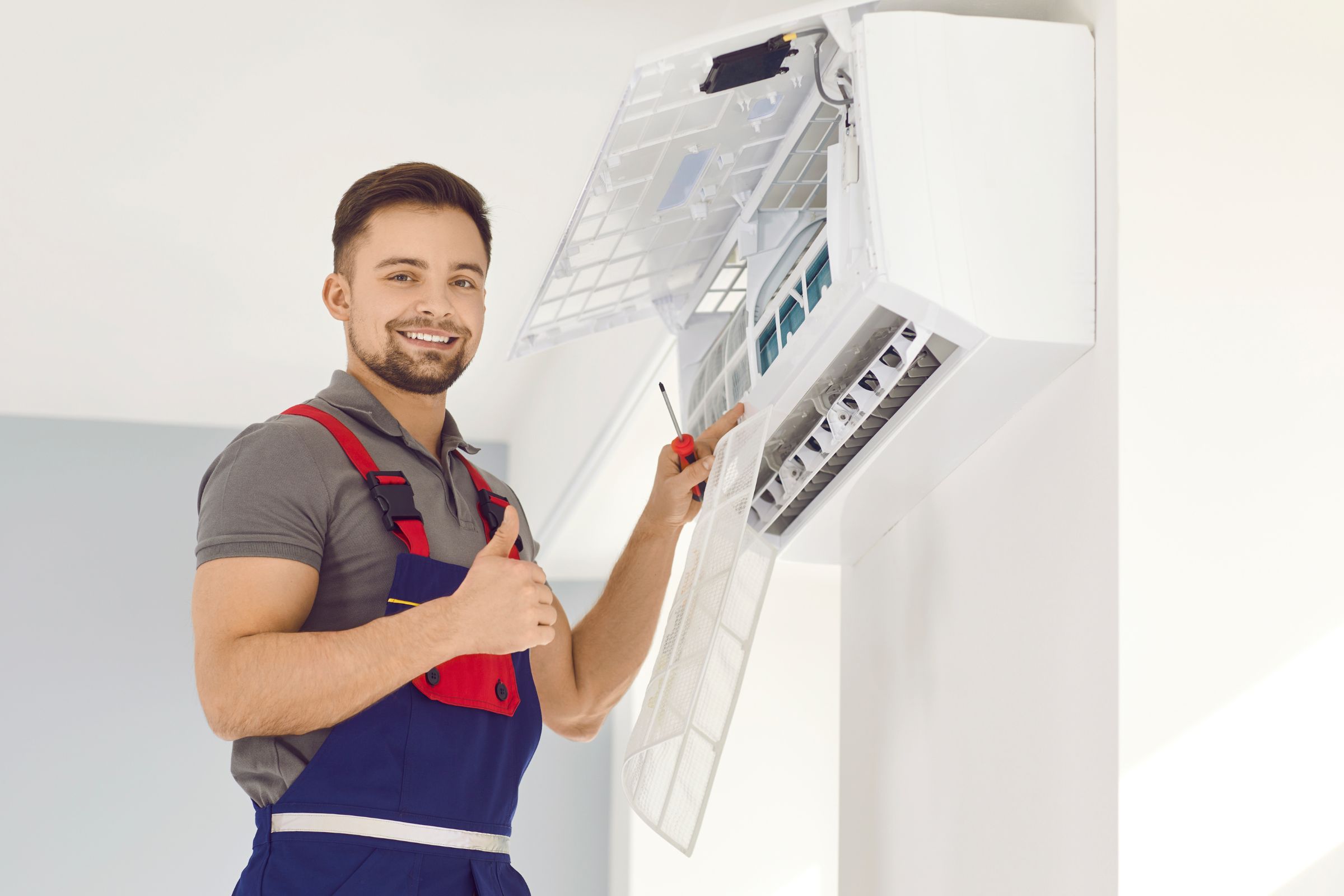 A smiling man in overalls and an apron shows a thumbs up, promoting HVAC mold removal services in Miami, FL.