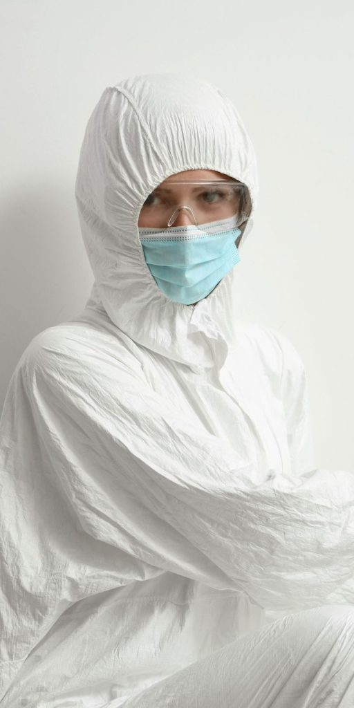 A man dressed in a white protective suit and mask, engaged in mold removal services in Miami, FL.